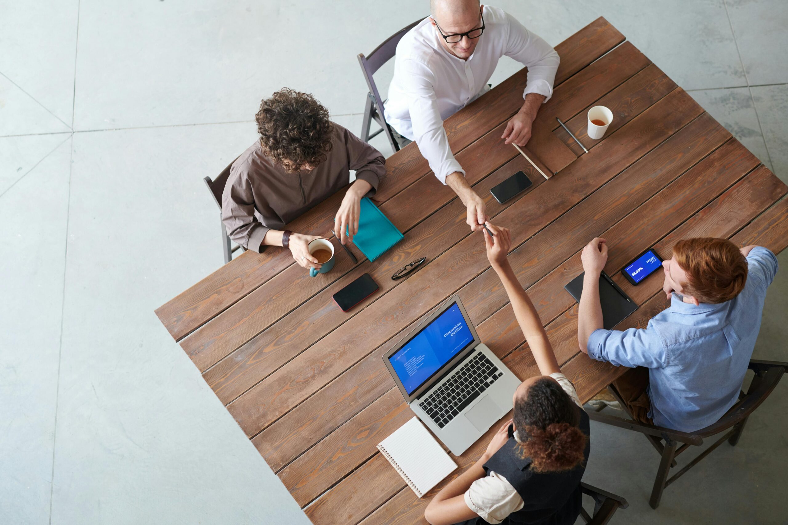 Four People Sitting Beside Wooden Table